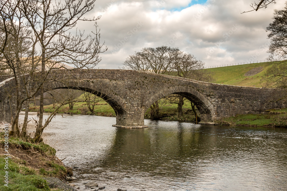 Stone bridge over the river Lune in Cumbria on an overcast day in early spring. Stone bridge over the river Lune in Cumbria on an overcast day in early spring.