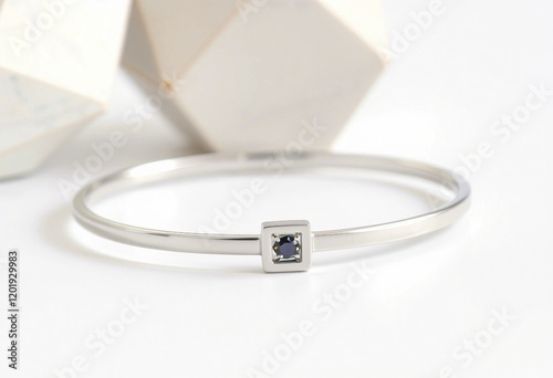 Stylish bracelet crafted from sterling silver, featuring a central blue gemstone accent.

