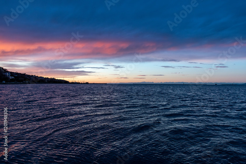 Muggia (Trieste, Italy): colourful sunset over the Adriatic Sea rippled by the waves  photo