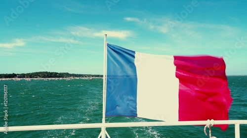 flag of france waving in the wind on a boat overlooking the ocean