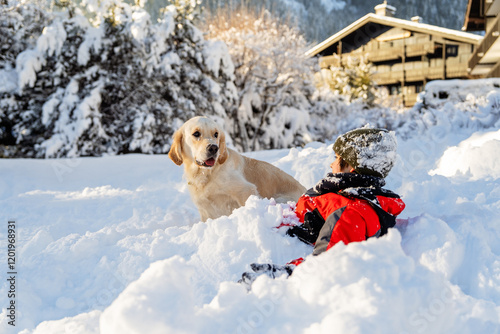 Child playing with golden retriever in snow