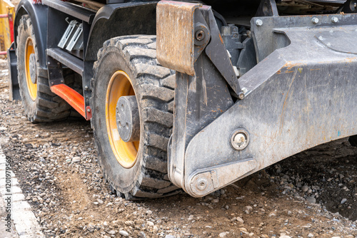 Hydraulic ground support and stabilizer on an multi purpose excavator on wheels. Prevention of tipping.  Close up. photo