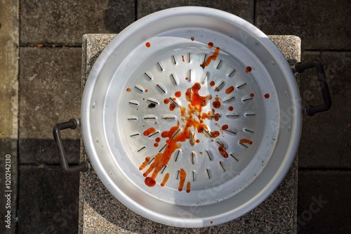 A plate of a pan-fried pork smeared a sauce on the chair.