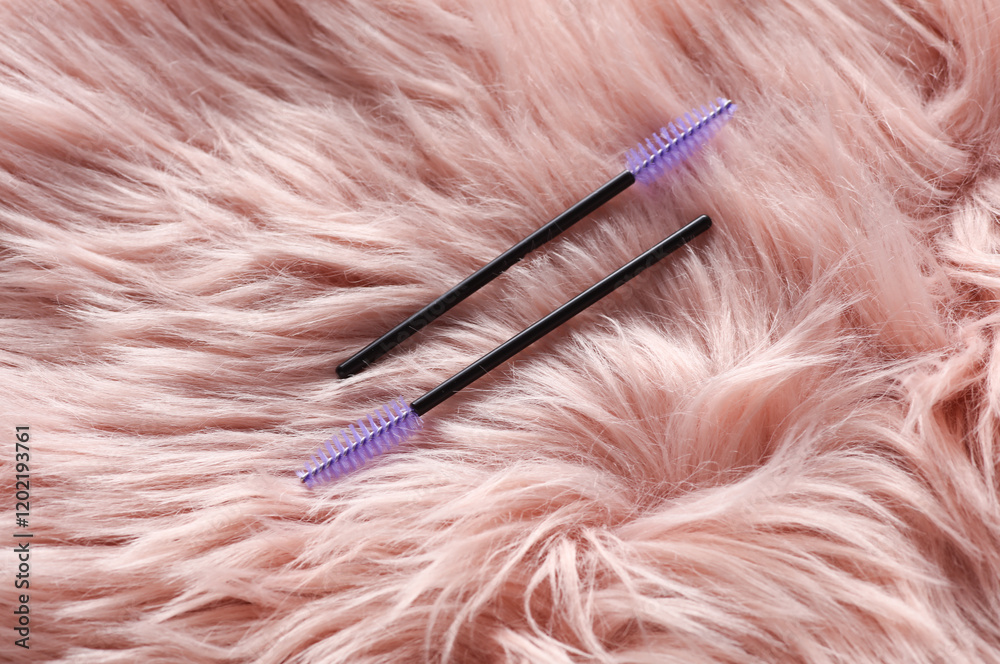 Naklejka premium Eyelash brushes on pink fur background