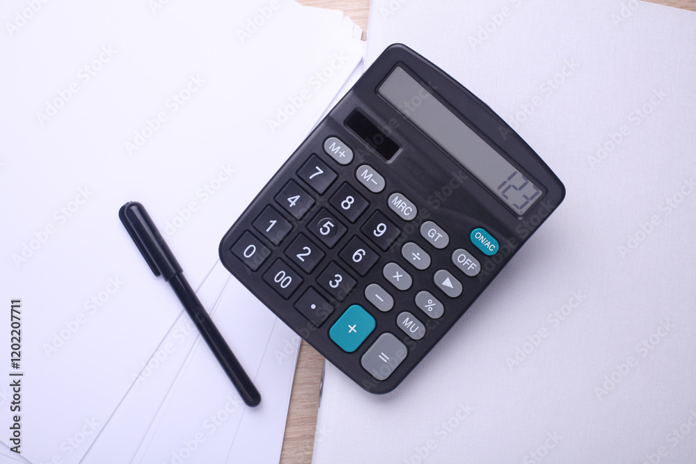 Black classic calculator with pen, paper sheets and folder on table. Business concept. Top view Black classic calculator with pen, paper sheets and folder on table. Business concept. Top view