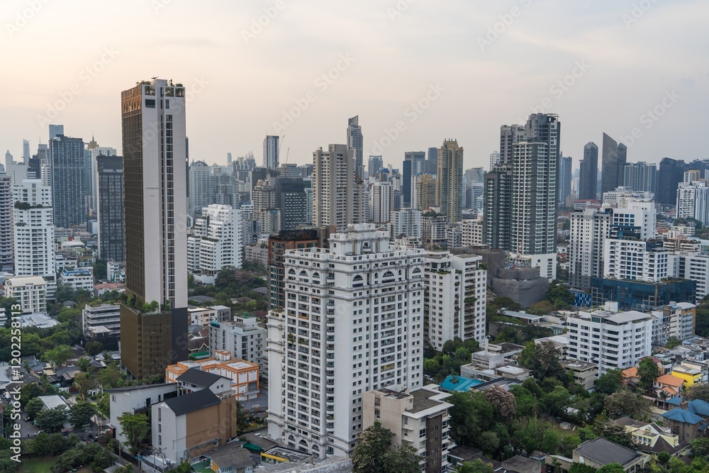 Obraz premium City skyline of Bangkok featuring modern buildings and lush greenery during sunset