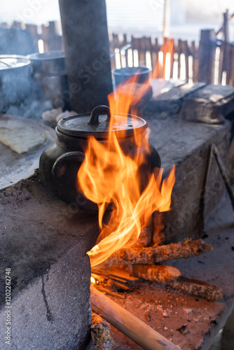 Black ceramic pot over cooking fire in outdoor kitchen, Oaxaca, Mexico photo