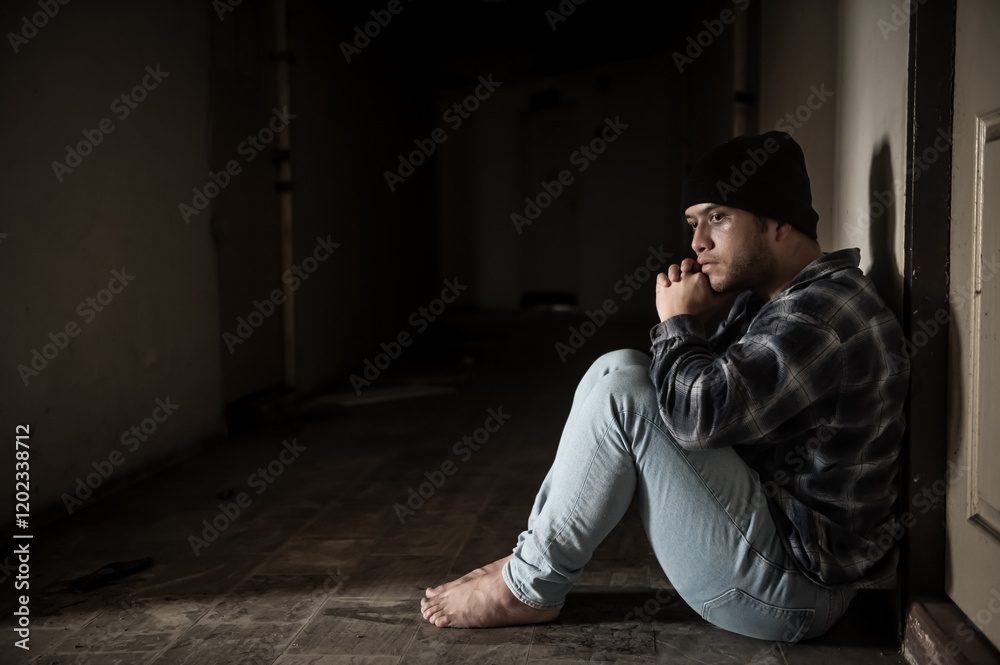 A drug addict is paranoid after taking drugs, sitting in the hallway of an abandoned building. A drug addict is paranoid after taking drugs, sitting in the hallway of an abandoned building.