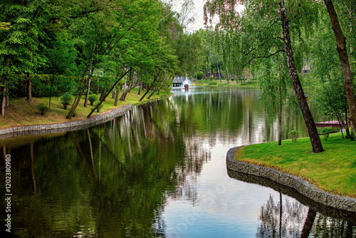 Serenity by the river as nature reflects in calm waters of a peaceful park