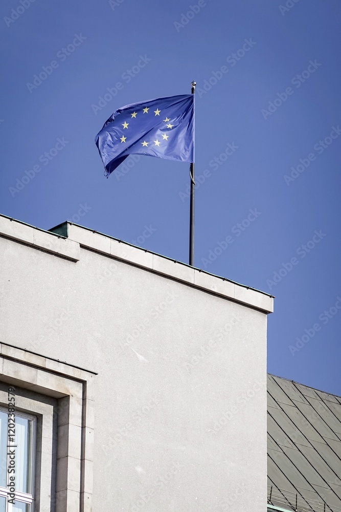 Flag of European Union waving in wind on building, blue sky