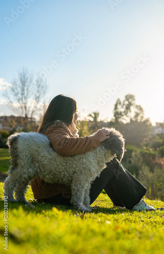 Wallpaper Mural Young woman sitting in an urban park with her dog, looking at the horizon. Torontodigital.ca