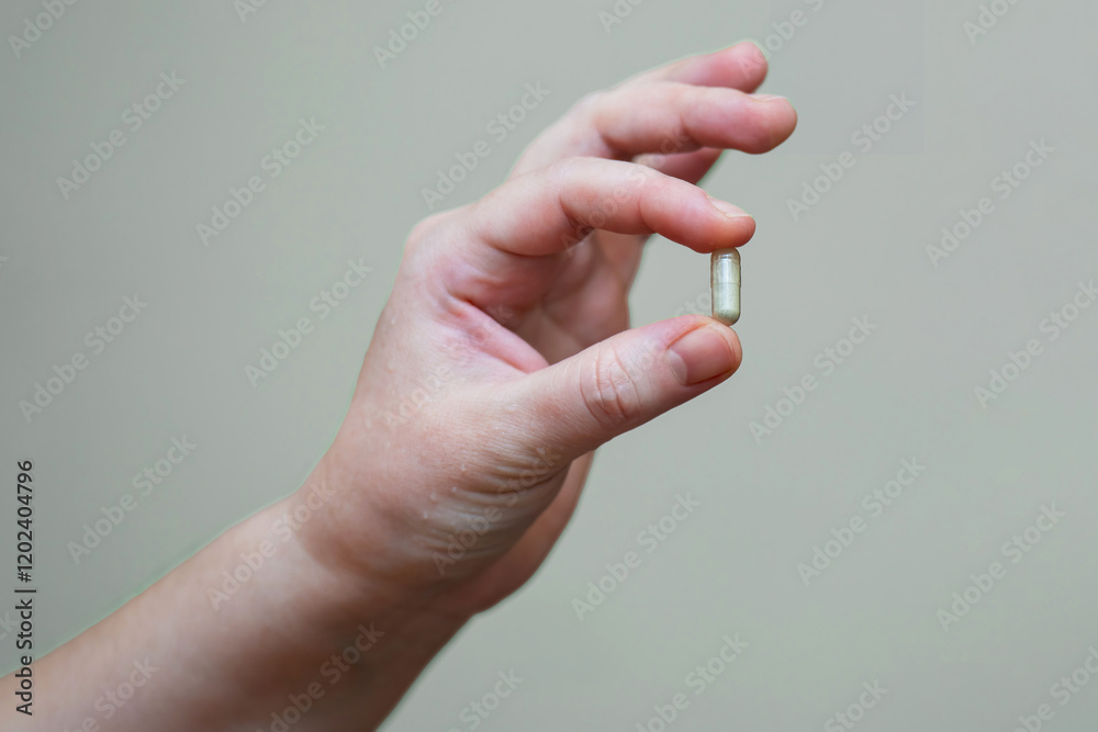 woman's hand holding a chelated iron capsule, designed to boost hemoglobin levels. Ideal for health and wellness related content woman's hand holding a chelated iron capsule, designed to boost hemoglobin levels. Ideal for health and wellness related content