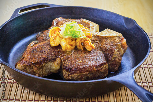 grilled porterhouse steak topped with sautéed butter shrimp photo