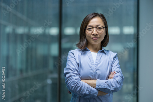 Portrait of confident serious woman inside office, Asian businesswoman looking focused at camera. Office worker working in evening.