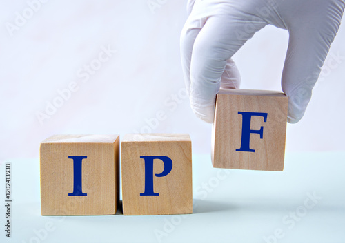 Cubes with the abbreviation IPF in the hand of a doctor. photo