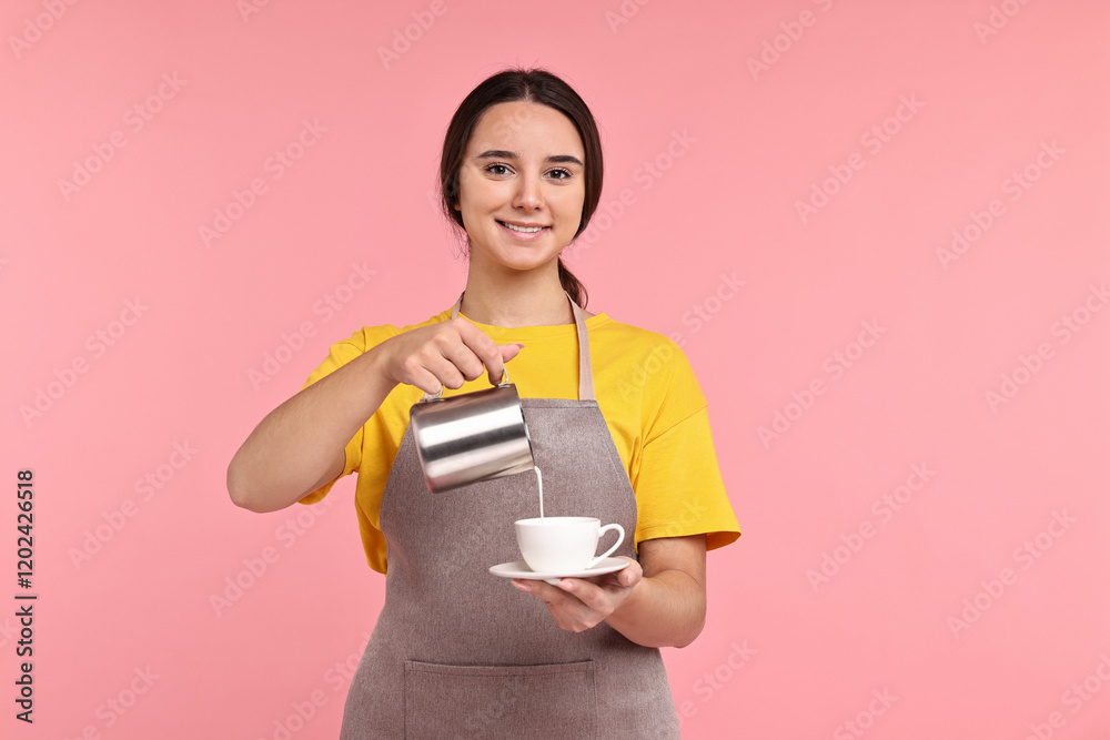 Girl in apron pouring milk from pitcher into cup of coffee on pink background. Work for teenagers Girl in apron pouring milk from pitcher into cup of coffee on pink background. Work for teenagers
