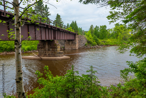 Obraz na płótnie A steel bridge, supported by concrete and stone blocks, over a river in northern Minnesota. w salonie