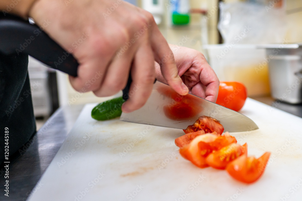 A close-up of hands skillfully slicing a ripe tomato on a white cutting board in a kitchen setting. Fresh vegetables are visible, emphasizing culinary preparation and healthy cooking. A close-up of hands skillfully slicing a ripe tomato on a white cutting board in a kitchen setting. Fresh vegetables are visible, emphasizing culinary preparation and healthy cooking.