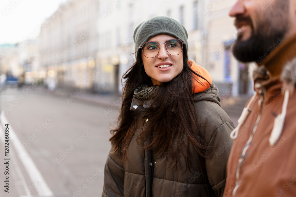 Naklejka premium Young woman smiling and walking in city street with friend
