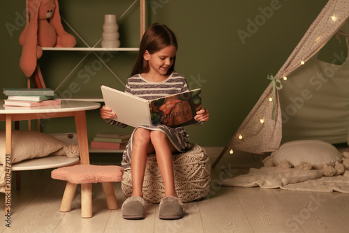 Cute little girl reading fa...