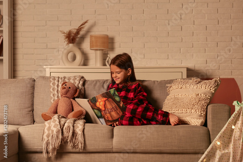 Cute little girl reading fa...