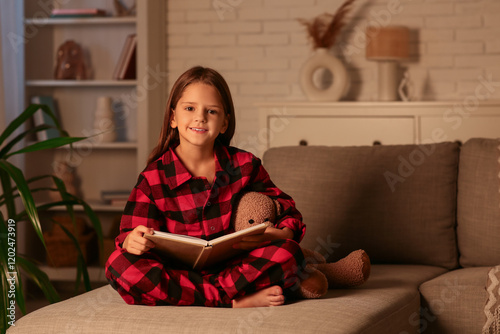 Cute little girl reading fa...
