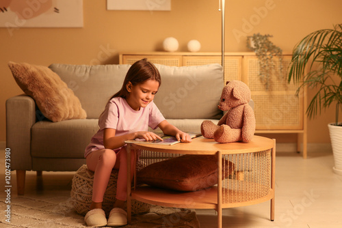 Cute little girl reading bo...