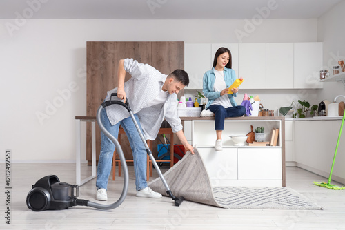 Young couple cleaning moder...