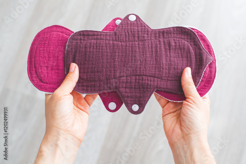 woman hands holding reusable cloth muslin menstrual pads in sustainable eco-friendly concept, promoting zero-waste alternatives for feminine hygiene products. Concept of sustainability and self-care