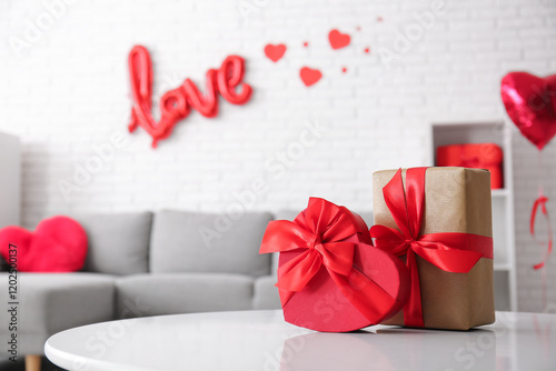 Table with gift boxes in stylish living room, closeup. Valentine's Day celebration photo