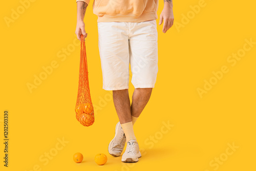 Young man holding net bag w...