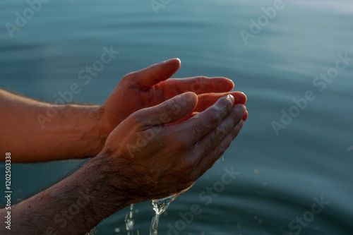 hands of the person in water on sunset
