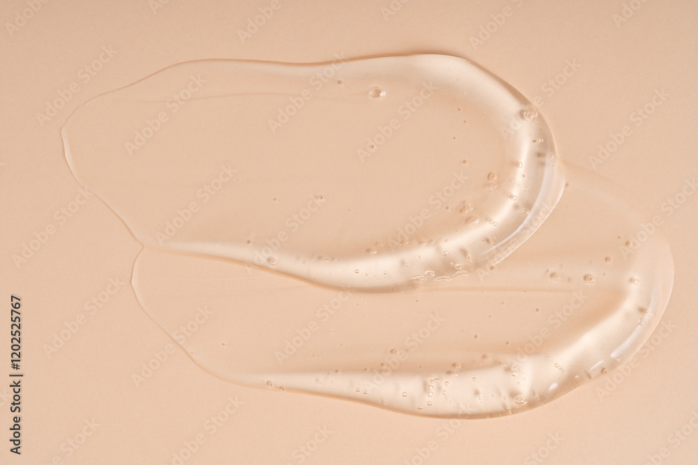 Fototapeta premium Squeezed cosmetic clear cream gel texture Isolated on beige background. Close up transparent serum drop smear
