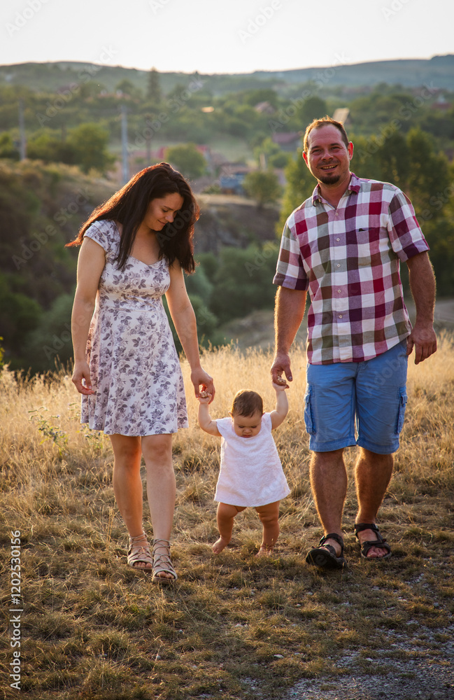 happy young family of four in summer at sunset
