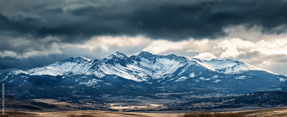 Dramatic snow-capped mountain range under a stormy sky. Dramatic snow-capped mountain range under a stormy sky.