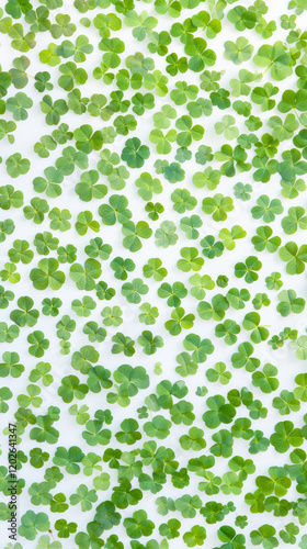 Green Clover Leaves Pattern on White Background. Concept of St. Patrick's Day, Luck, Nature's Beauty and Irish Heritage. Abundant Foliage for Celebrations. Copy space. Vertical