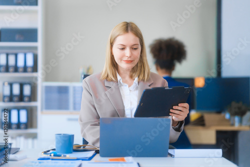 A young Russian woman in formal suit works diligently in business office, analyzing financial charts, using a desktop PC, calculator while contributing to various business strategies and projects.