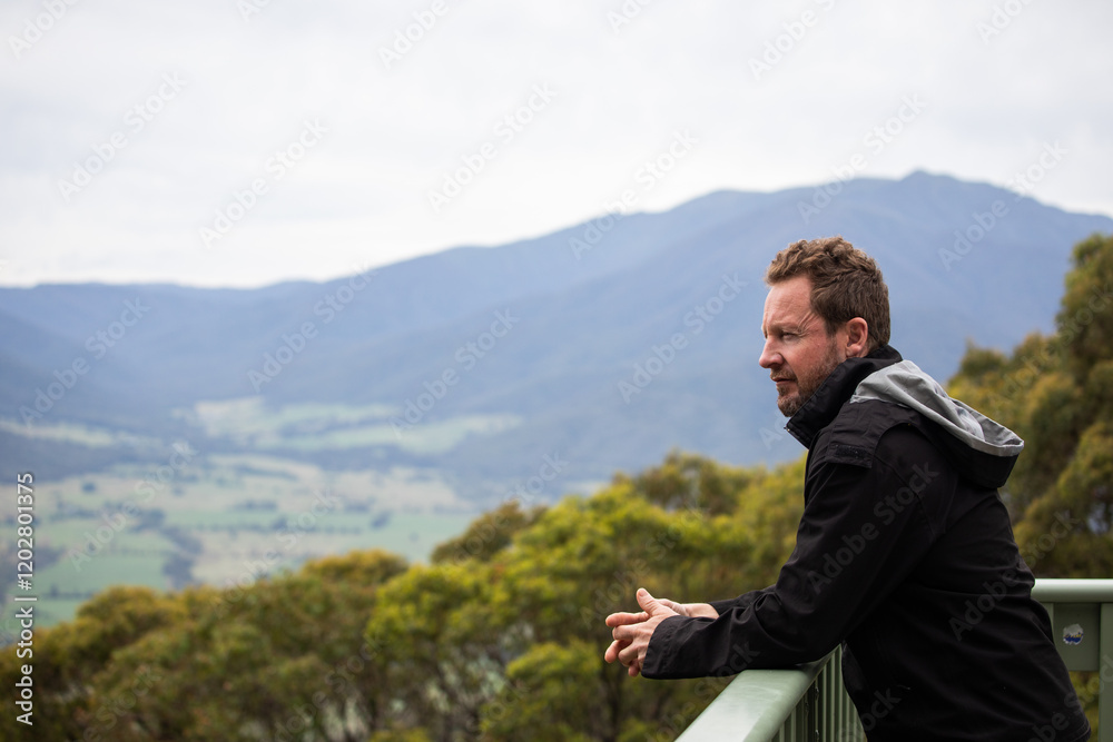 caucasian man black rain jacket hiking walk mountains trek