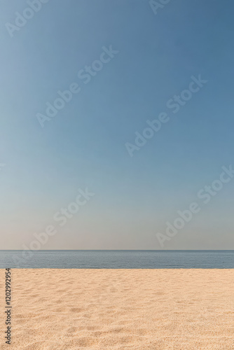 Sandy beach under clear blue sky with calm ocean view at sunset photo