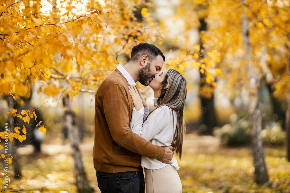 Profile view of young happy couple hugging and kissing in public park. Profile view of young happy couple hugging and kissing in public park.