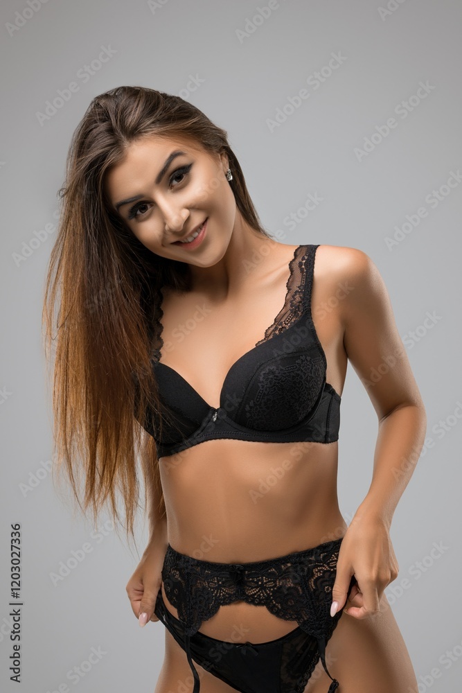 Fototapeta premium Model in black lingerie exudes elegance and confidence in studio