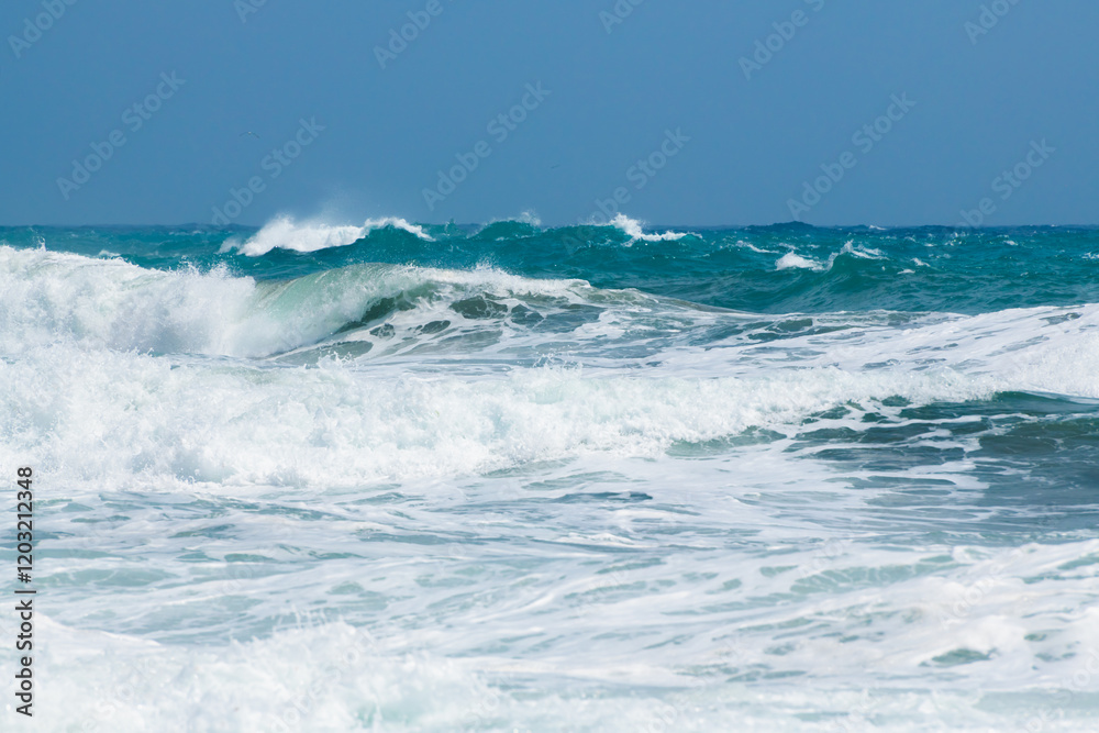 Waves on the beach in windy day. Blue sea and the blue sky.
