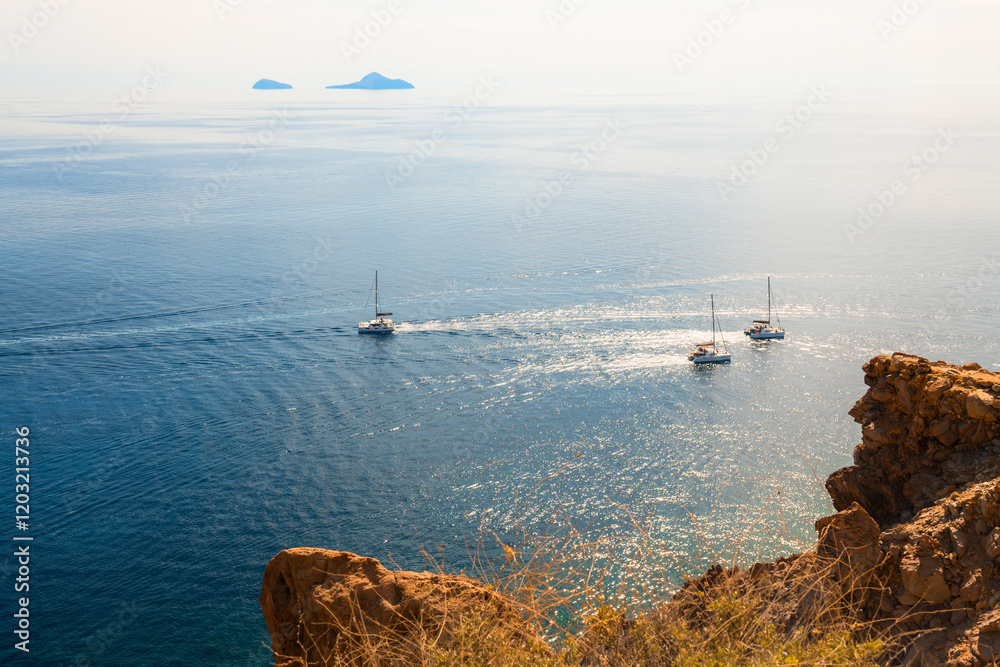 Santorini island, Greece. Yachts sailing near the sea coast.
