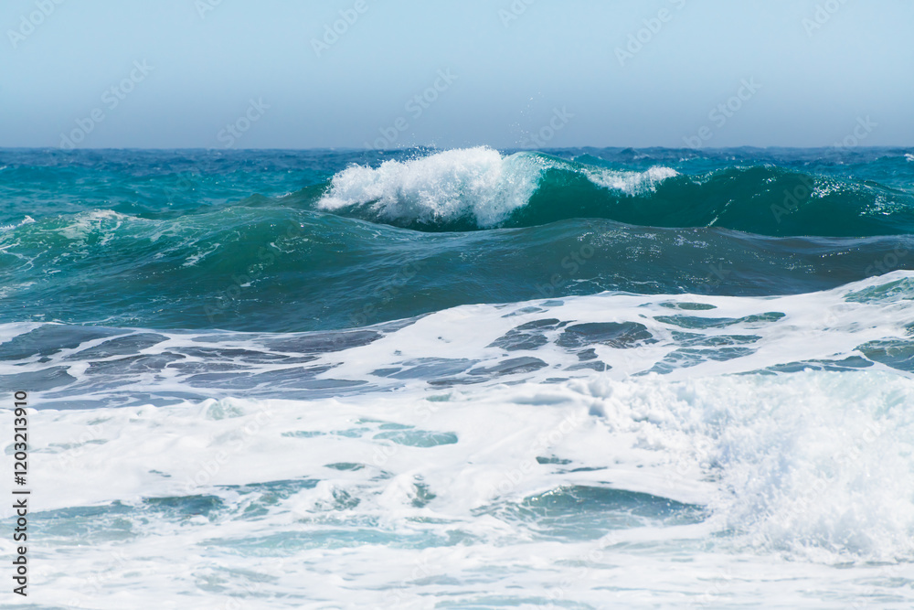 Waves on the beach in windy day. Blue sea and the blue sky.