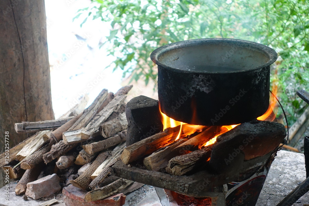 In a simple and old-fashioned way, cooking food with a stainless steel pot and an Anglo charcoal stove. to get a dark sooty color over a long time. The charcoal stove has a red light on it. In a simple and old-fashioned way, cooking food with a stainless steel pot and an Anglo charcoal stove. to get a dark sooty color over a long time. The charcoal stove has a red light on it.
