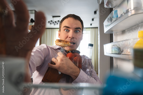 Man hungry guy open empty refrigerator point of view from inside fridge. businessman looks for food in the fridge and chooses what to eat.