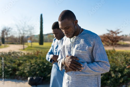 Photography Two senegalese men praying outdoors in traditional clothing during ramadan