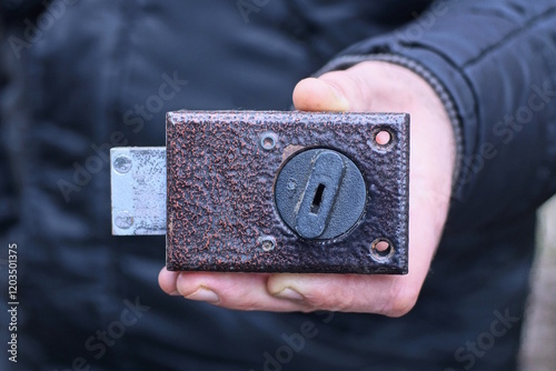 hand hold one old iron brown  black mortise lock on the street