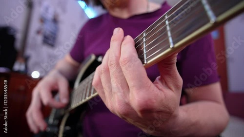 A musician passionately strums an electric guitar, fingers dancing on the fretboard in a cozy studio, creating beautiful melodies