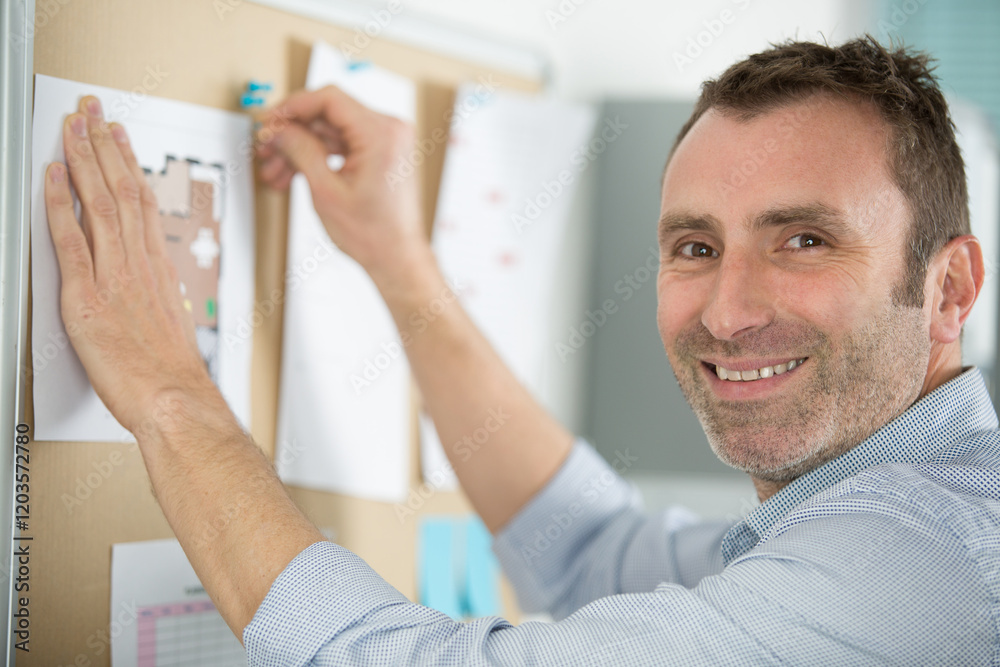 Obraz premium male office worker writing on whiteboard for work schedule